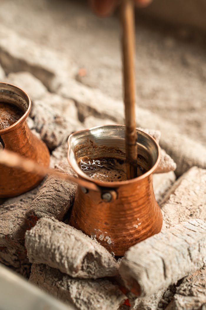 client-stories-img Authentic Turkish coffee brewing in a copper pot over hot ash, showcasing traditional methods.