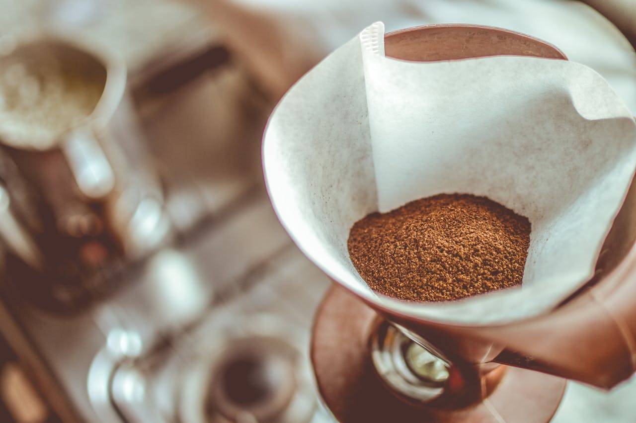 A close-up of ground coffee in a pour-over filter on a stovetop background, ideal for coffee enthusiasts.